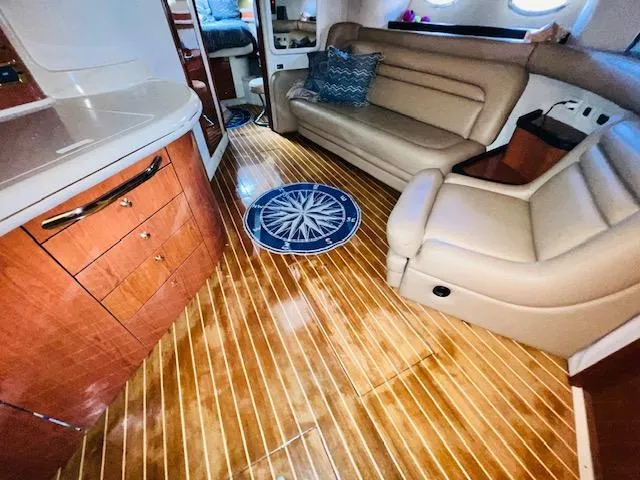 Slide: The Image of Interior of 1999 Sea Ray 460 Sundancer yacht with wooden flooring and beige seating. - 22