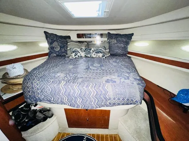 Slide: The Image of 1999 Sea Ray 460 Sundancer cabin with cozy bed and nautical decor. - 24