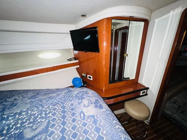 Slide: The Image of Interior cabin of 1999 Sea Ray 460 Sundancer with bed, TV, and vanity. - 25