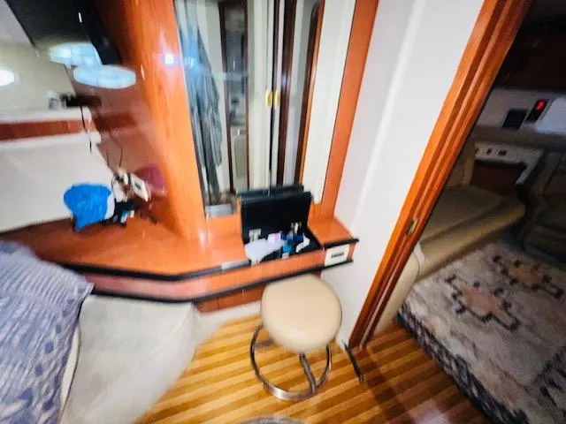 Slide: The Image of Interior of 1999 Sea Ray 460 Sundancer yacht with wooden accents and seating area. - 26