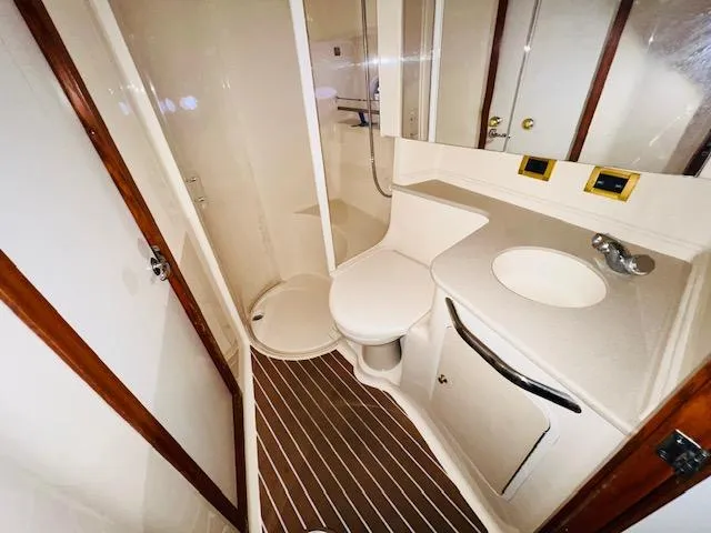 Slide: The Image of Bathroom interior of 1999 Sea Ray 460 Sundancer yacht, featuring modern fixtures and wood accents. - 27