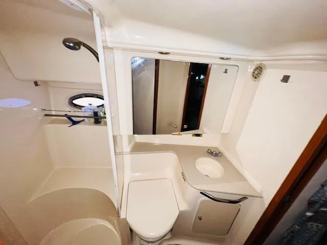 Slide: The Image of Bathroom interior of 1999 Sea Ray 460 Sundancer yacht, featuring shower, sink, and toilet. - 28