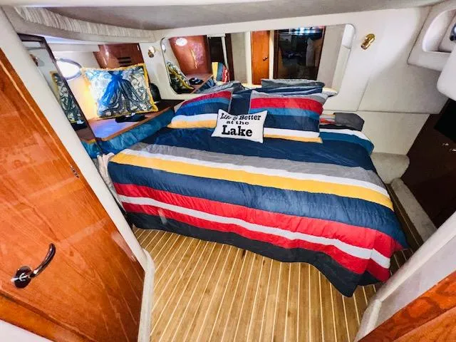 Slide: The Image of Interior of 1999 Sea Ray 460 Sundancer with colorful bedding and decorative pillows. - 29