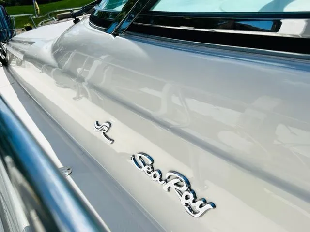 Slide: The Image of 1999 Sea Ray 460 Sundancer yacht, sleek white exterior with chrome logo detailing. - 4