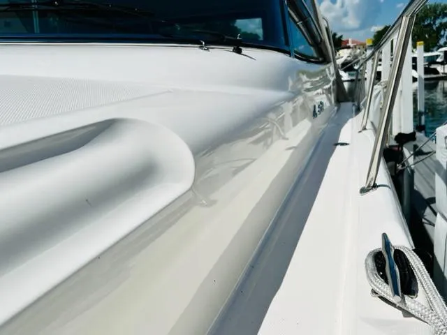 Slide: The Image of 1999 Sea Ray 460 Sundancer yacht, sleek white exterior, docked under a clear blue sky. - 5