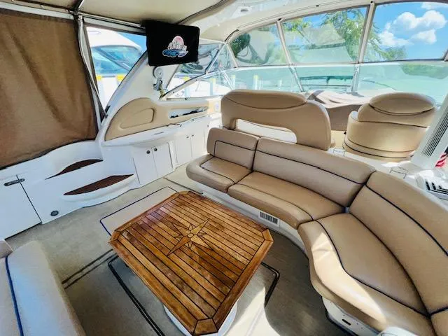 Slide: The Image of Luxurious interior of 1999 Sea Ray 460 Sundancer yacht with elegant seating and wooden table. - 9