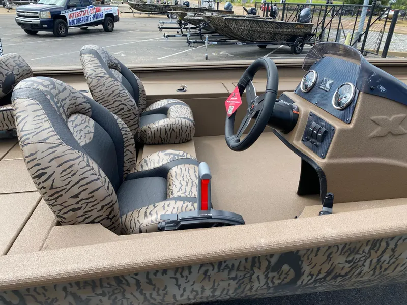 Slide: The Image of 2025 Xpress XP200 boat interior with camo seats and steering console. - 13