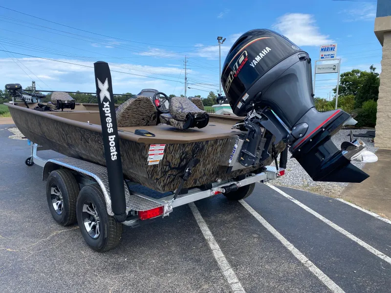 Slide: The Image of 2025 Xpress XP200 boat on trailer with Yamaha outboard motor, parked outdoors. - 2