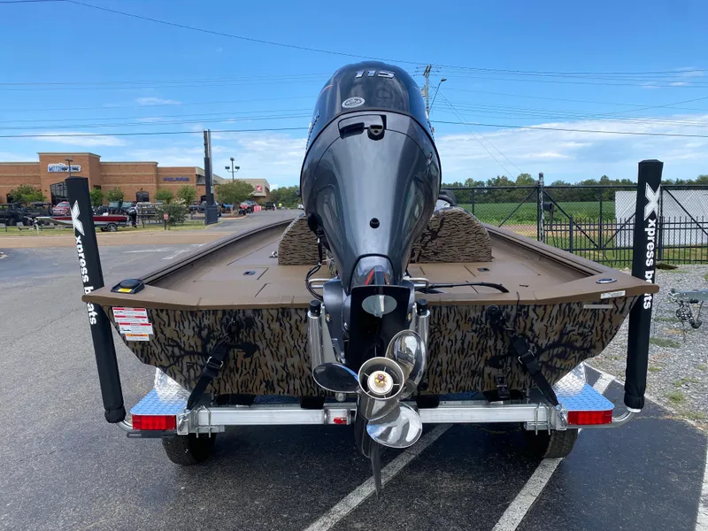 Slide: The Image of 2025 Xpress XP200 boat on trailer, rear view with outboard motor, parked outdoors. - 3
