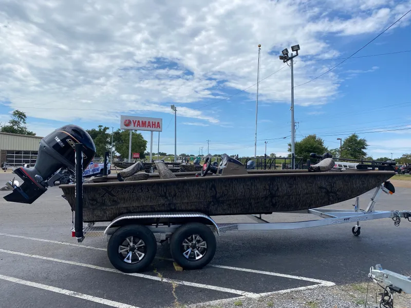 Slide: The Image of 2025 Xpress XP200 boat on trailer in parking lot, Yamaha sign in background. - 5