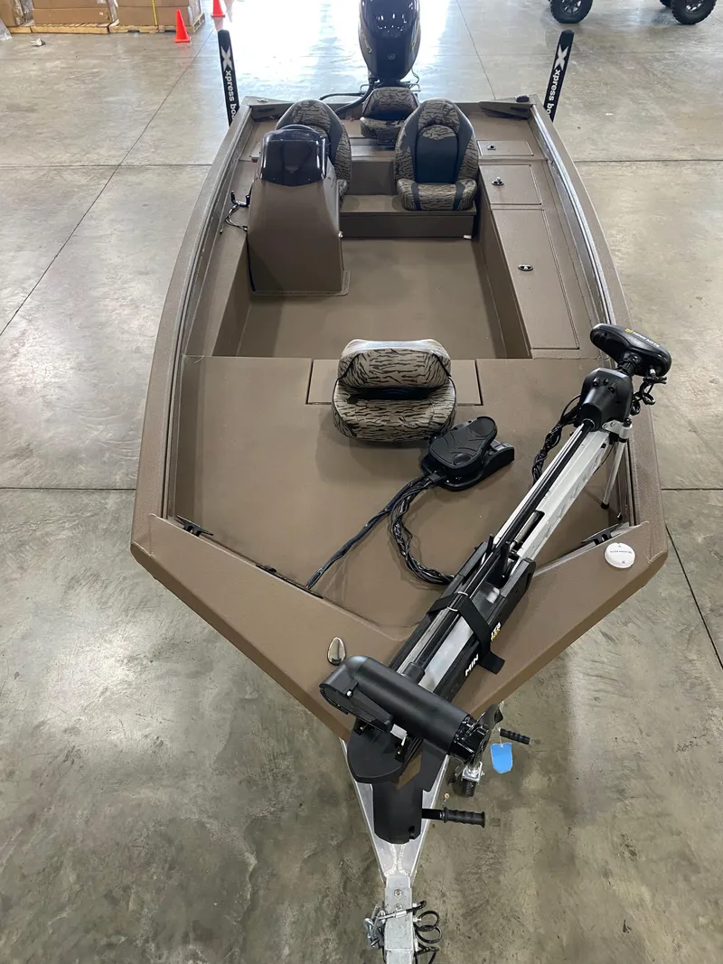 Slide: The Image of 2025 Xpress XP200 boat with trolling motor, dual seats, and spacious deck in a showroom. - 8