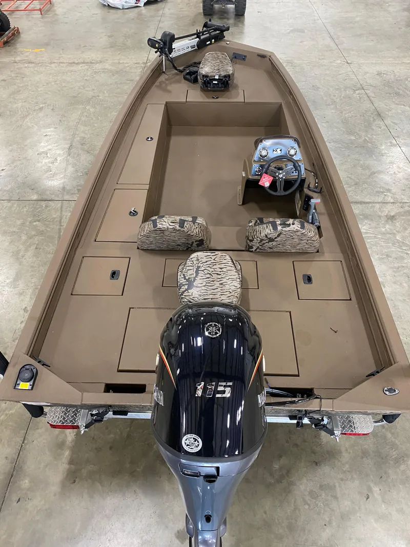 Slide: The Image of 2025 Xpress XP200 boat with camo seats and powerful outboard motor in a showroom. - 9