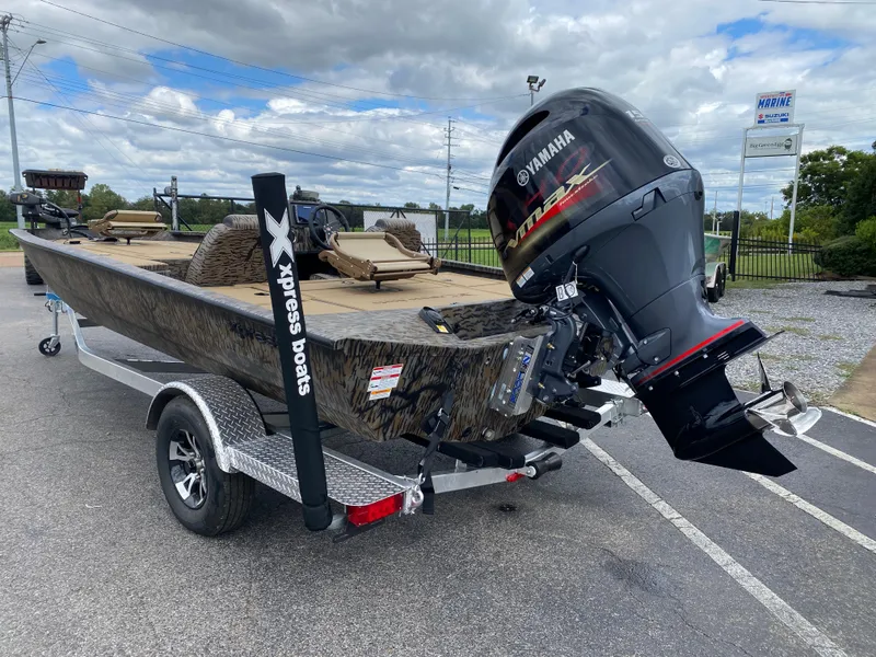 Slide: The Image of 2025 Xpress H20C Crappie boat with Yamaha motor on a trailer, parked outdoors. - 2