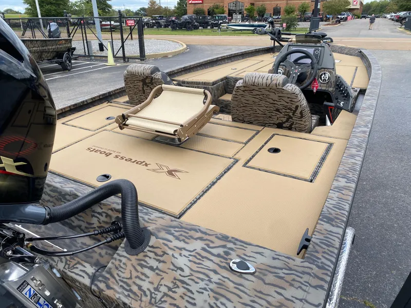 Slide: The Image of 2025 Xpress H20C Crappie boat with camo design, parked outdoors. - 9