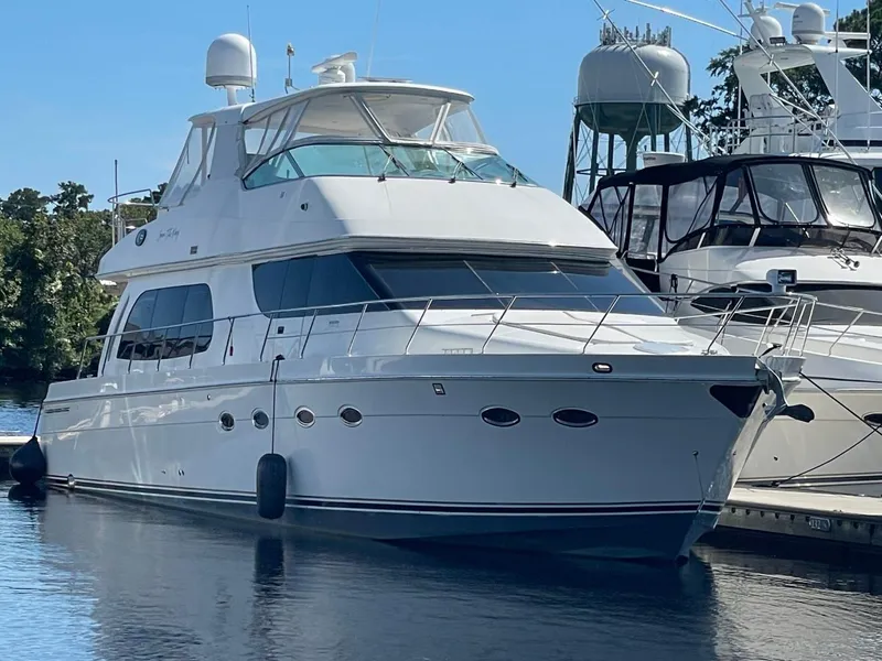 Slide: The Image of 2006 Carver 56 Voyager yacht docked at marina, clear blue sky background. - 0