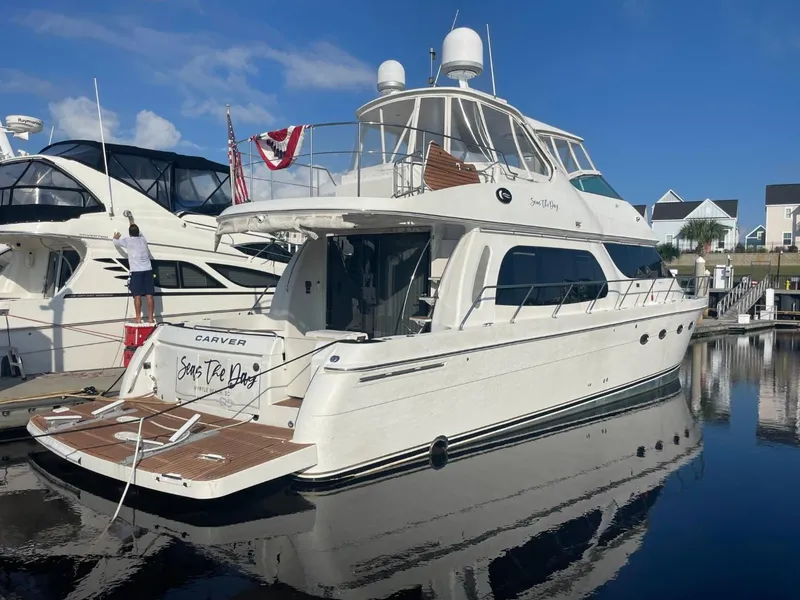 Slide: The Image of 2006 Carver 56 Voyager yacht docked at marina under clear blue sky. - 1