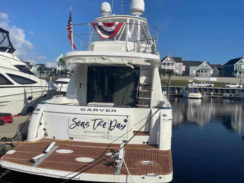 Slide: The Image of 2006 Carver 56 Voyager yacht docked, displaying "Seas The Day" at Myrtle Beach marina. - 12