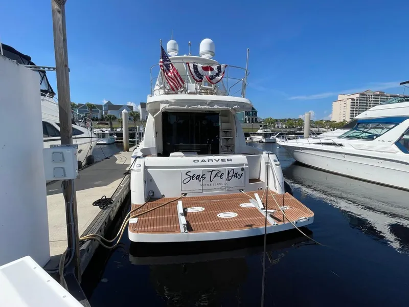 Slide: The Image of 2006 Carver 56 Voyager yacht docked at marina, rear view with American flag. - 4