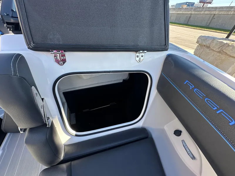 Slide: The Image of 2025 Regal LS4 Surf boat storage compartment with open lid, showcasing interior space. - 27