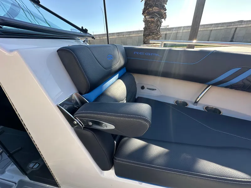 Slide: The Image of 2025 Regal LS4 Surf boat interior with black leather seating and blue accents. - 28