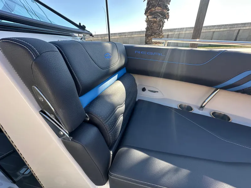 Slide: The Image of 2025 Regal LS4 Surf boat interior with black leather seating and blue accents. - 29