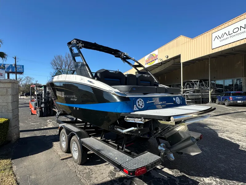 Slide: The Image of 2025 Regal LS4 Surf boat on trailer outside dealership. - 3
