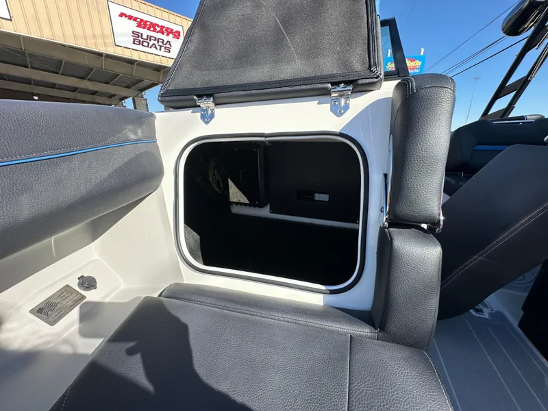 Slide: The Image of 2025 Regal LS4 Surf boat interior storage compartment with black seating. - 31