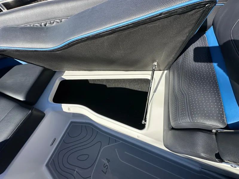 Slide: The Image of 2025 Regal LS4 Surf boat interior storage compartment with black and blue seating. - 34