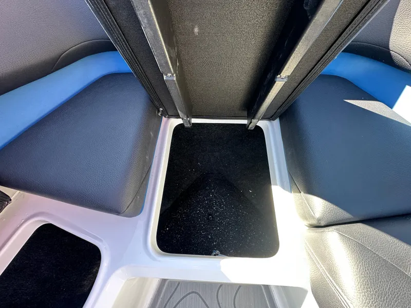 Slide: The Image of 2025 Regal LS4 Surf boat interior storage compartment with black and blue seating. - 36