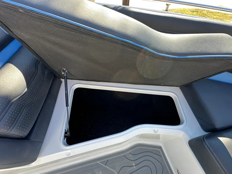 Slide: The Image of 2025 Regal LS4 Surf boat interior storage compartment with cushioned seating. - 38