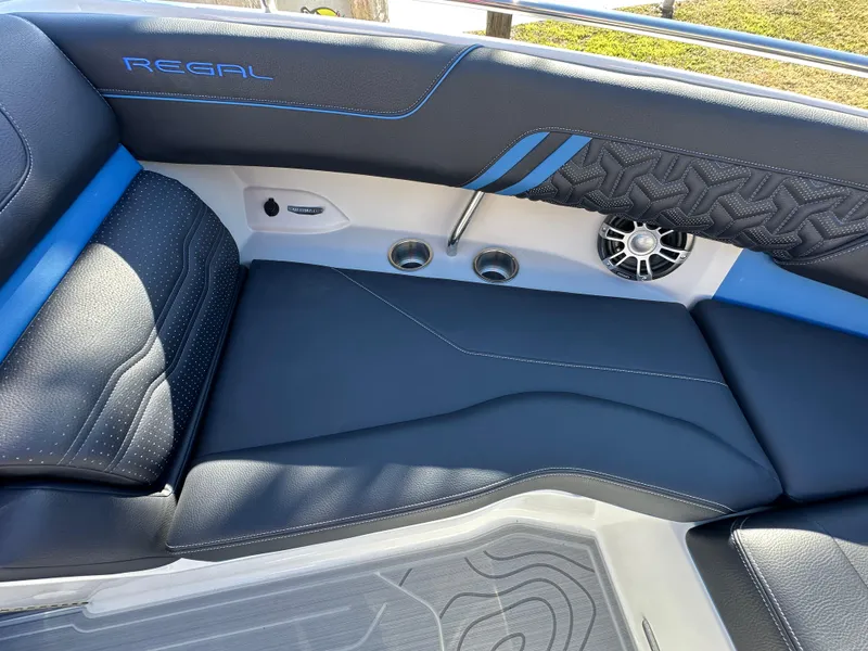 Slide: The Image of 2025 Regal LS4 Surf boat interior with black and blue seating and speaker system. - 39