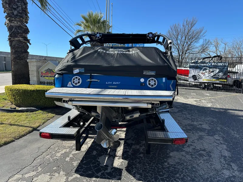Slide: The Image of 2025 Regal LS4 Surf boat on trailer, rear view, parked outdoors. - 4