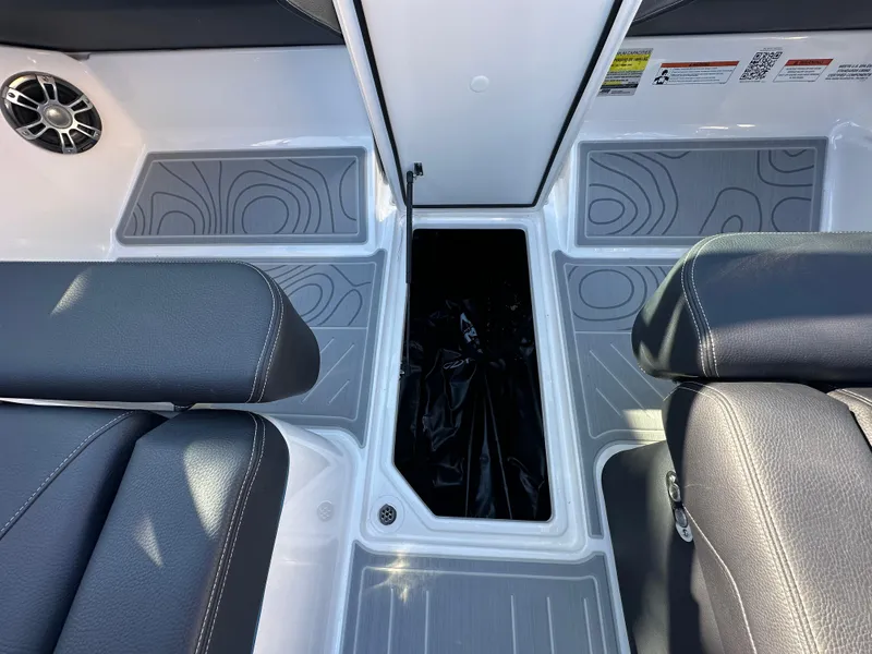 Slide: The Image of 2025 Regal LS4 Surf boat interior with gray seating and storage compartment. - 42