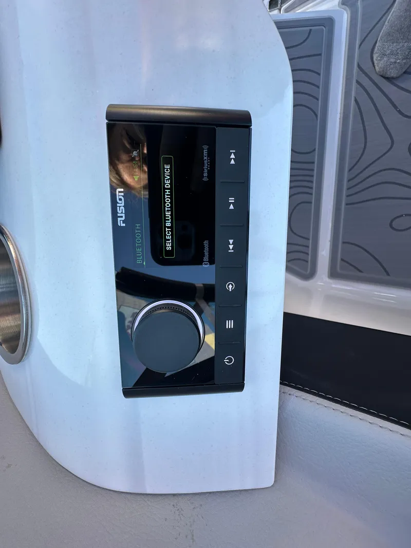 Slide: The Image of 2025 Regal LS4 Surf boat audio control panel with digital display and buttons. - 48