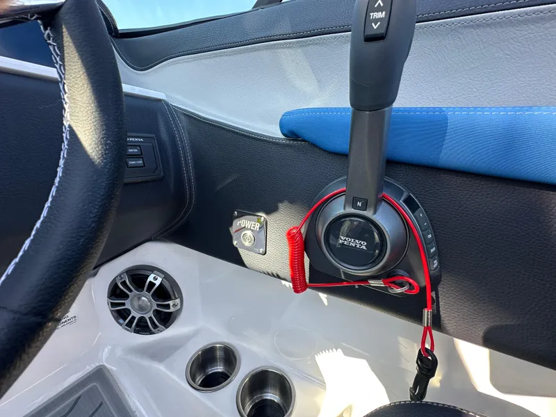 Slide: The Image of 2025 Regal LS4 Surf boat interior with control panel and cup holders. - 56