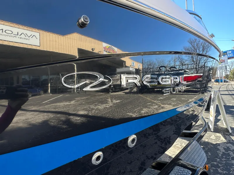 Slide: The Image of 2025 Regal LS4 Surf boat with sleek black exterior and logo. - 7
