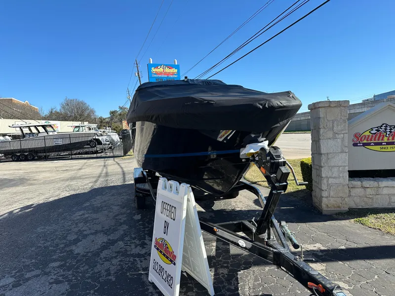 Slide: The Image of 2025 Regal LS4 Surf boat covered on a trailer in a parking lot. - 8