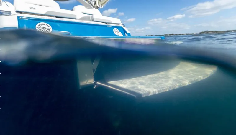 Slide: The Image of 2025 Regal LS4 Surf boat partially submerged in water, showcasing underwater features. - 96