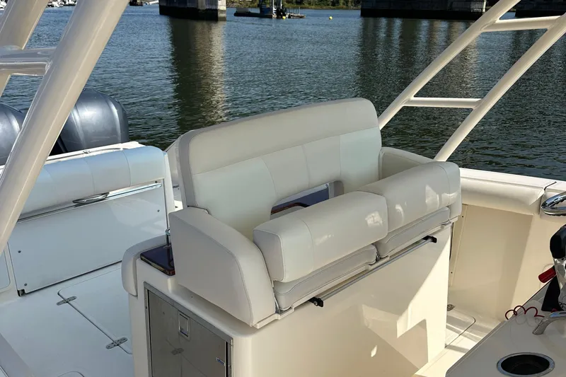 Slide: The Image of 2014 Pursuit S 280 Sport boat interior with white seating and water view. - 17