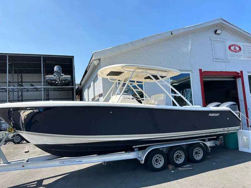 Slide: The Image of 2014 Pursuit S 280 Sport boat on trailer outside a warehouse. - 2