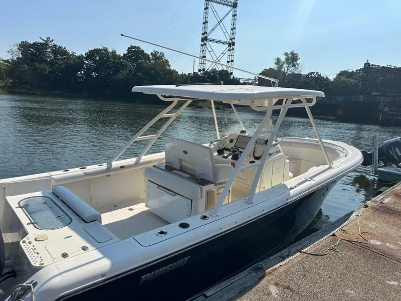 Slide: The Image of 2014 Pursuit S 280 Sport boat docked by a serene waterfront. - 5