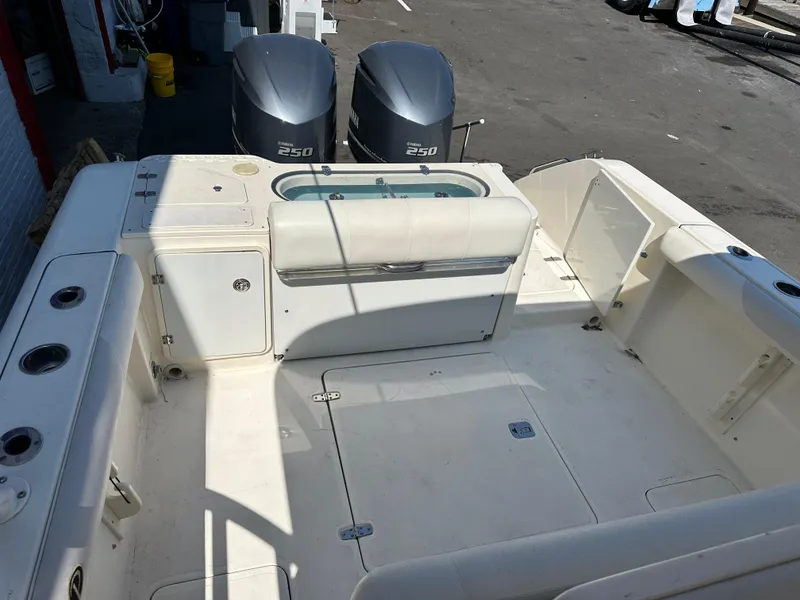 Slide: The Image of 2014 Pursuit S 280 Sport boat deck with twin engines and seating area. - 7