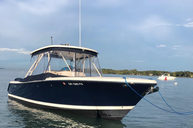 Slide: The Image of 2014 Pursuit S 280 Sport boat anchored on calm water. - 14