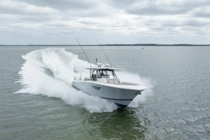 Slide: The Image of 2023 Pursuit S 428 Sport boat speeding on open water under cloudy skies. - 10