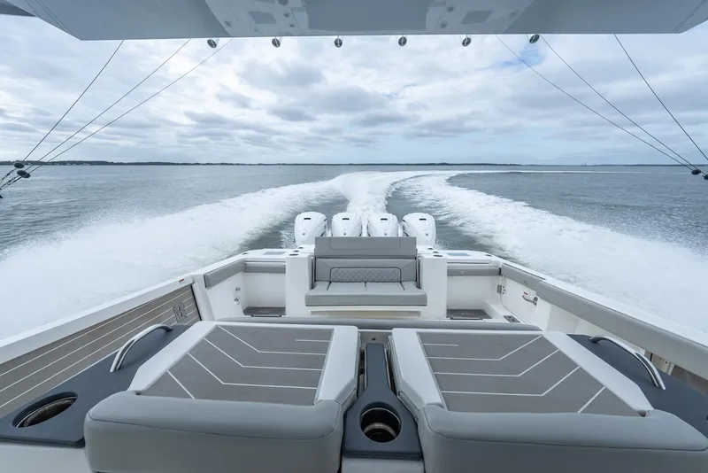 Slide: The Image of 2023 Pursuit S 428 Sport boat cruising on open water, rear view. - 30