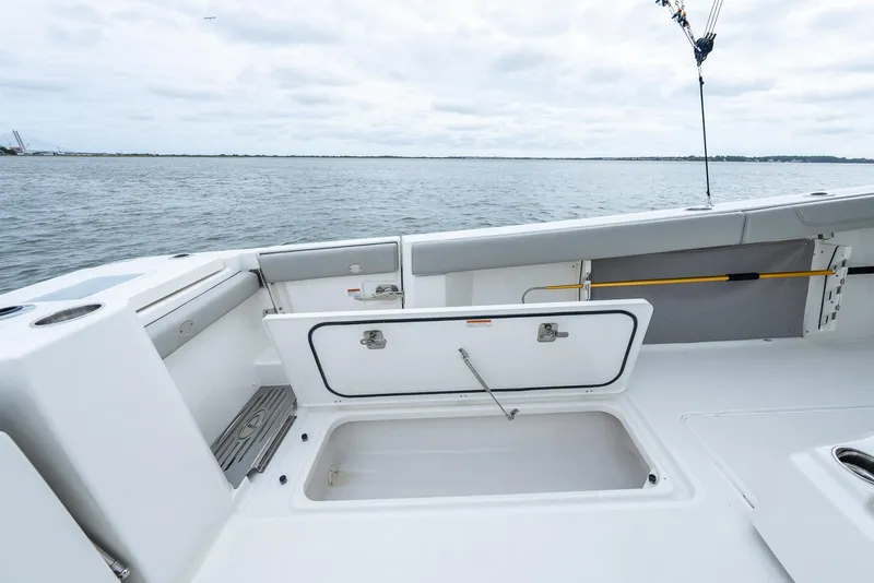 Slide: The Image of 2023 Pursuit S 428 Sport boat deck with open storage compartment, ocean view. - 41