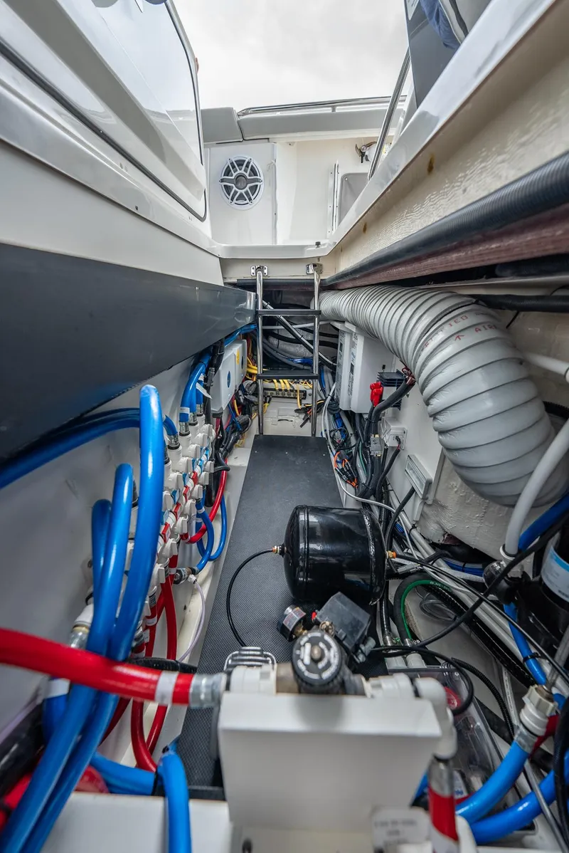 Slide: The Image of 2023 Pursuit S 428 Sport boat engine compartment with wiring and hoses. - 47