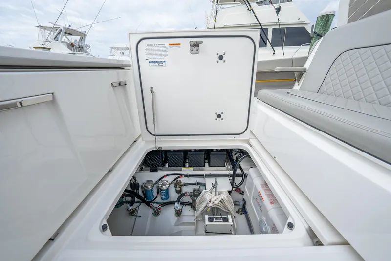 Slide: The Image of 2023 Pursuit S 428 Sport boat storage compartment with visible wiring and equipment. - 48