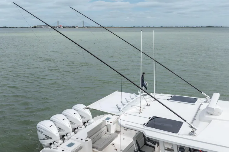 Slide: The Image of 2023 Pursuit S 428 Sport boat with multiple outboard engines on calm water. - 5