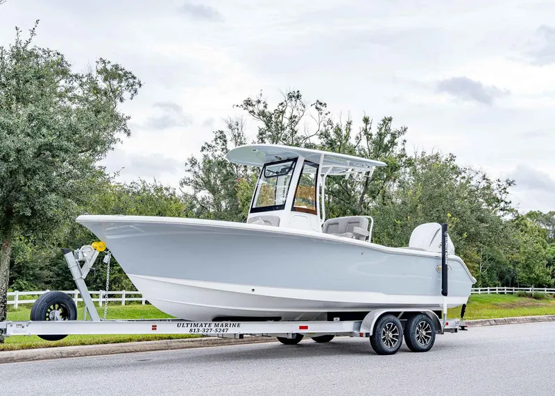 Slide: The Image of 2025 Sea Hunt Ultra 239 SE boat on trailer, parked on roadside. - 1